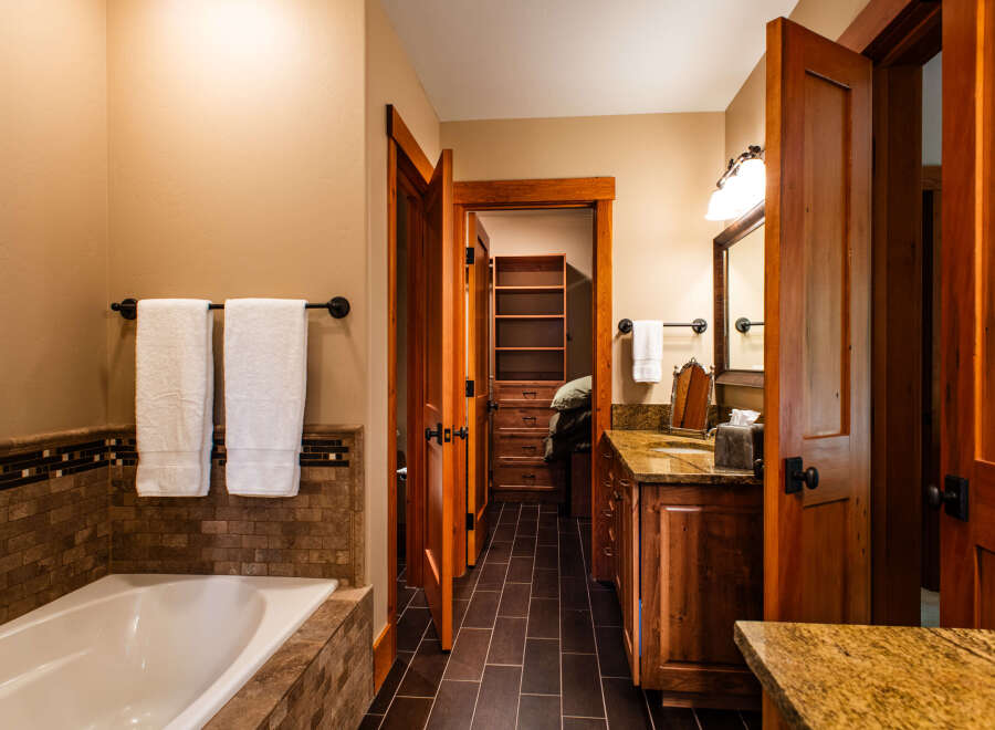 Experience luxury in this master bathroom featuring a deep soaking tub surrounded by elegant tile work.