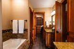 Experience luxury in this master bathroom featuring a deep soaking tub surrounded by elegant tile work.