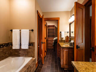 Experience luxury in this master bathroom featuring a deep soaking tub surrounded by elegant tile work.