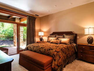 Experience luxurious comfort in this master bedroom, featuring a king-sized bed with a rich paisley comforter and plush accent pillows.