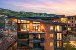 Experience luxury mountain living in this stunning modern residence, featuring expansive floor-to-ceiling windows that showcase breathtaking panoramic views of the surrounding peaks and vibrant sunset skies.
