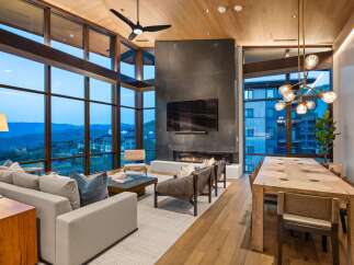 Experience luxury living with this stunning open-concept great room, featuring a dramatic floor-to-ceiling fireplace and expansive windows that frame breathtaking mountain views.