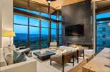 Experience luxury living with this stunning modern living room, featuring a grand fireplace and floor-to-ceiling windows that offer breathtaking mountain views.