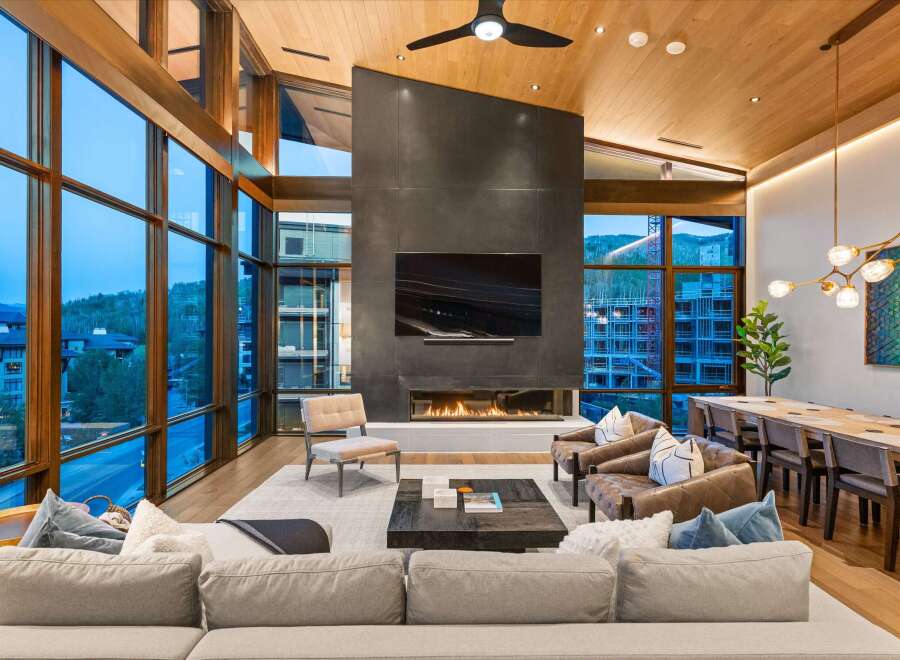 Experience luxury living in this stunning modern great room, featuring floor-to-ceiling windows that offer breathtaking mountain views.