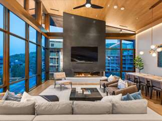Experience luxury living in this stunning modern great room, featuring floor-to-ceiling windows that offer breathtaking mountain views.