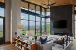Experience luxury living in this stunning mountain view home, featuring a grand living room with a modern fireplace and expansive floor-to-ceiling windows.
