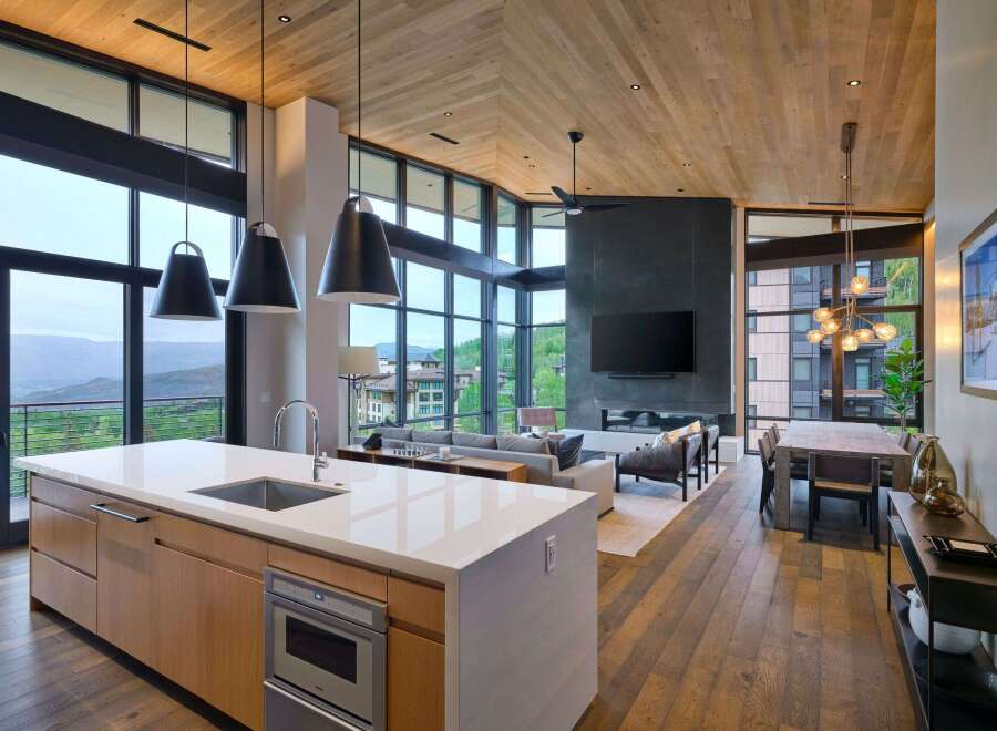 Experience luxury mountain living in this stunning open-concept home, featuring a gourmet kitchen with a waterfall island and sleek cabinetry.