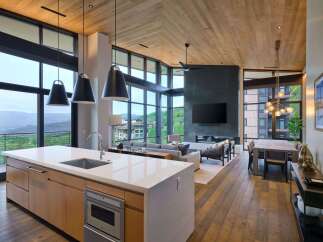 Experience luxury mountain living in this stunning open-concept home, featuring a gourmet kitchen with a waterfall island and sleek cabinetry.