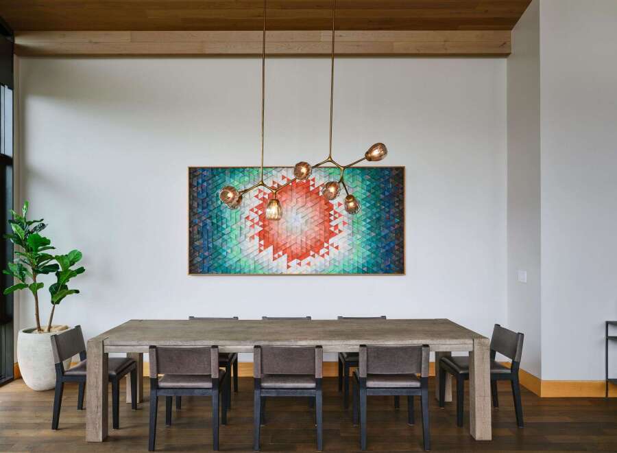 Experience sophisticated dining in this elegant space, featuring a large, rustic wooden table complemented by modern upholstered chairs.