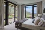 Experience luxury living with breathtaking mountain views from this stunning bedroom.