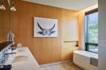 Experience luxury in this modern bathroom featuring a sleek double vanity and a freestanding soaking tub.
