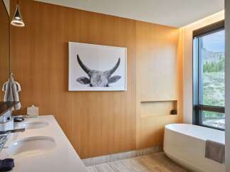 Experience luxury in this modern bathroom featuring a sleek double vanity and a freestanding soaking tub.