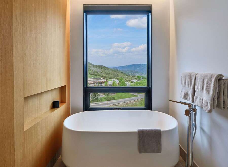 Experience ultimate relaxation in this luxurious bathroom featuring a freestanding soaking tub with a stunning mountain view.