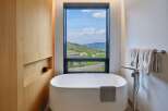 Experience ultimate relaxation in this luxurious bathroom featuring a freestanding soaking tub with a stunning mountain view.