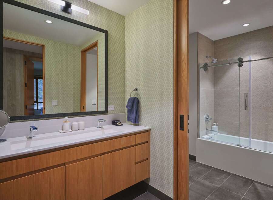 This modern bathroom features a sleek vanity with ample storage and a clean white countertop.