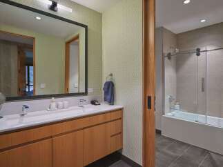 This modern bathroom features a sleek vanity with ample storage and a clean white countertop.