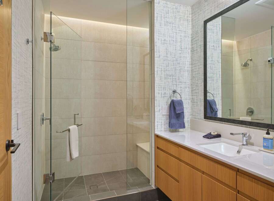 Experience modern luxury in this stunning bathroom featuring a spacious glass-enclosed shower with elegant tilework.