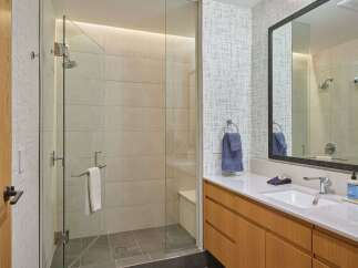 Experience modern luxury in this stunning bathroom featuring a spacious glass-enclosed shower with elegant tilework.