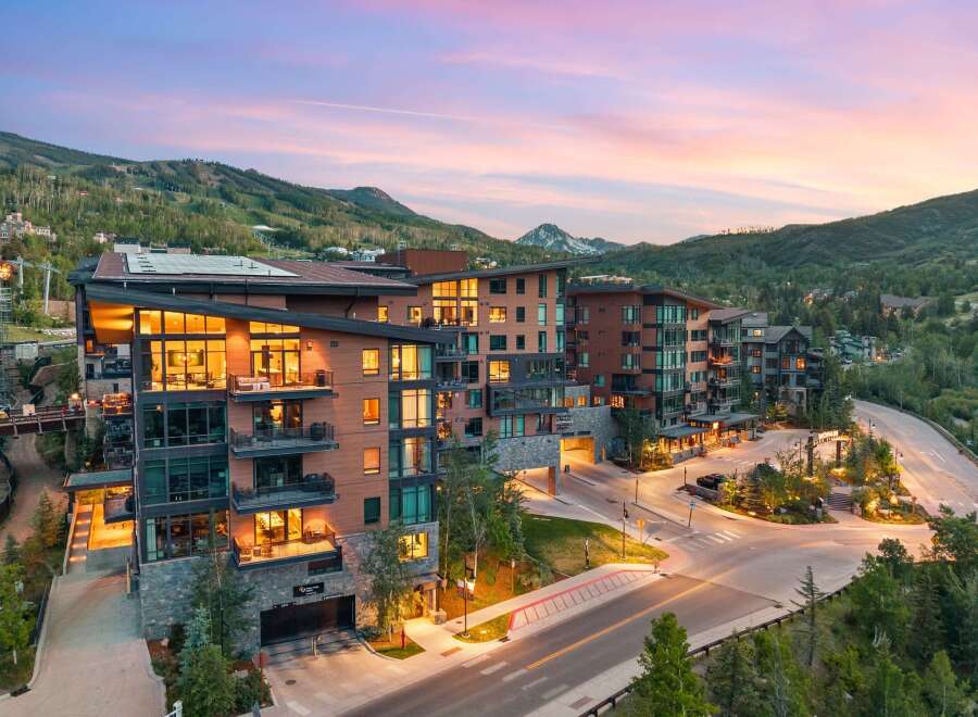 Experience luxury mountain living in this stunning contemporary condominium complex, nestled against a backdrop of majestic peaks.