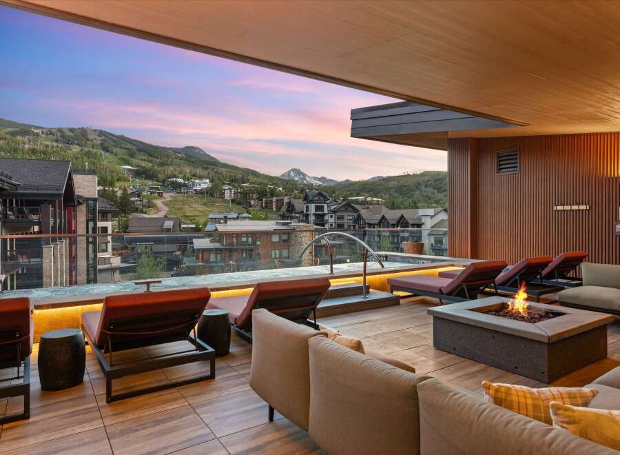 Experience luxury mountain living with this stunning rooftop deck, featuring a private hot tub and a cozy fire pit, perfect for enjoying breathtaking sunset views over the ski resort.
