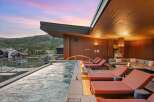 Experience luxury mountain living with this stunning rooftop spa featuring a relaxing hot tub and comfortable lounge area.