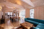 Experience modern living in this stunning open-concept space, featuring a vaulted wood-paneled ceiling and expansive windows showcasing a serene winter landscape.