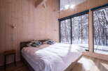 Experience serene winter living in this cozy bedroom, featuring a comfortable bed adorned with stylish pillows.