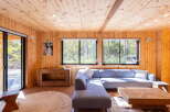 Experience serene living in this charming wooden cabin, featuring a spacious sectional sofa perfect for relaxation.