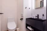 Discover this modern bathroom featuring a sleek, wall-mounted vanity with a black basin and integrated storage.
