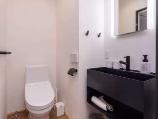 Discover this modern bathroom featuring a sleek, wall-mounted vanity with a black basin and integrated storage.