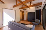 Experience modern living in this spacious open-concept living area, featuring exposed wooden beams and a bright, airy atmosphere.