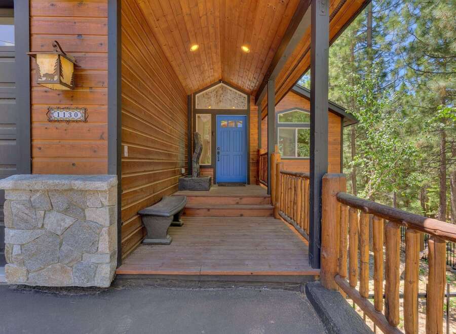 Welcome to this charming mountain retreat, featuring a rustic wooden exterior and a welcoming covered porch.