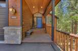 Welcome to this charming mountain retreat, featuring a rustic wooden exterior and a welcoming covered porch.