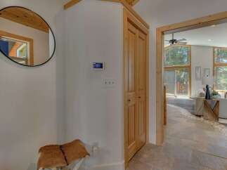 Step into this inviting entryway featuring a stylish round mirror and a unique hide-covered bench, perfect for a warm welcome.