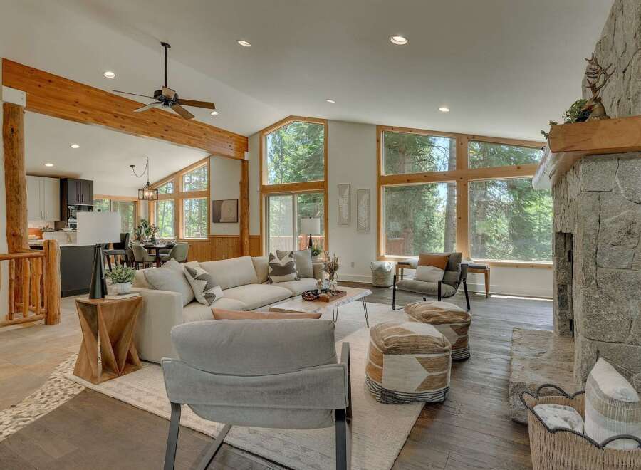 Experience the ultimate mountain retreat in this stunning living room, featuring a grand stone fireplace and expansive windows that bring the outdoors in.