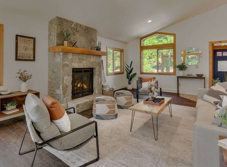 Cozy living room featuring a striking stone fireplace with a rustic wooden mantel, perfect for gathering on cool evenings.