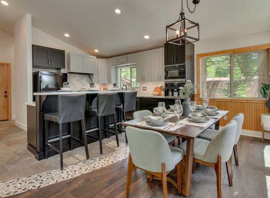 This modern kitchen and dining area features a sleek island with bar seating, perfect for casual meals or entertaining.