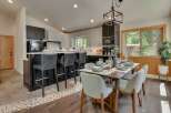 This modern kitchen and dining area features a sleek island with bar seating, perfect for casual meals or entertaining.