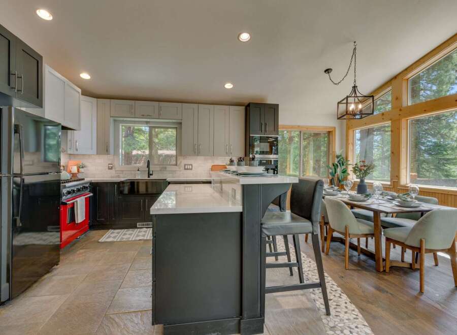 Experience modern living in this stunning kitchen featuring sleek gray cabinetry, a vibrant red range, and a spacious island perfect for entertaining.