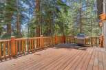 Enjoy outdoor living on this spacious wooden deck, perfect for entertaining or relaxing amidst the serene forest.