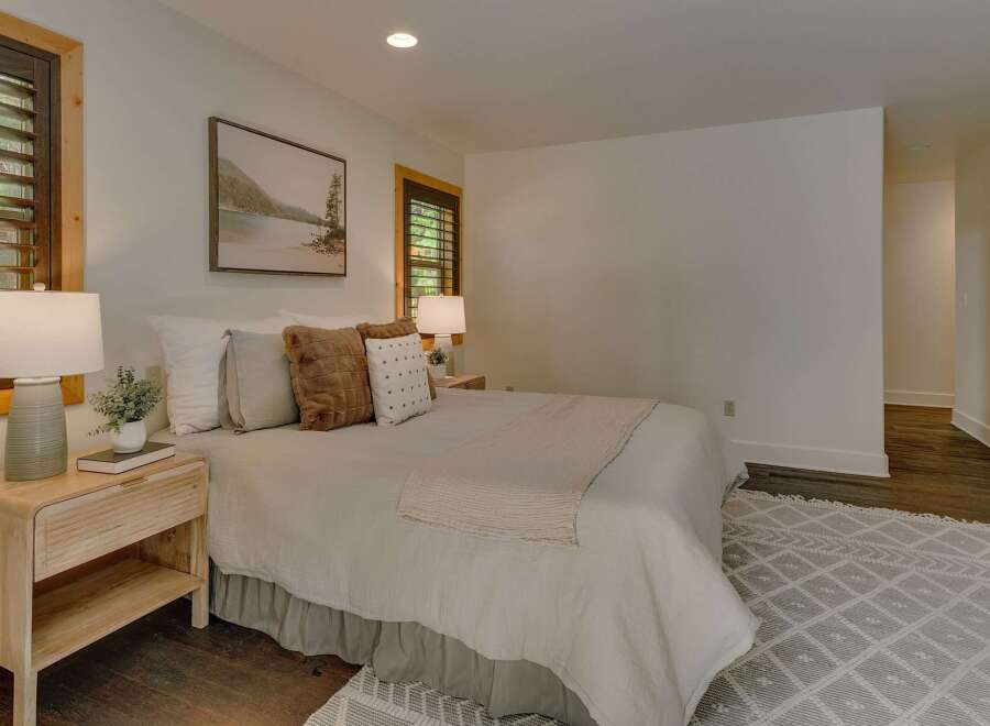 Experience serene comfort in this inviting bedroom, featuring a plush bed adorned with soft linens and decorative pillows.