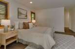 Experience serene comfort in this inviting bedroom, featuring a plush bed adorned with soft linens and decorative pillows.
