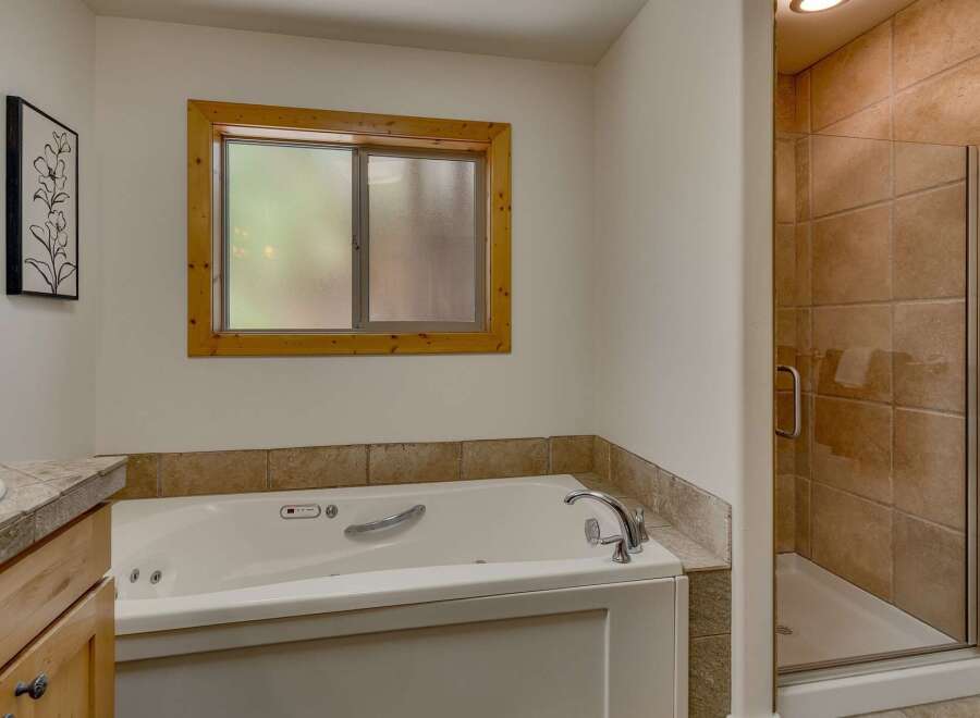 Indulge in relaxation in this luxurious bathroom, featuring a spacious jetted tub perfect for unwinding after a long day.