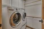 This laundry room features a stacked Whirlpool Duet washer and dryer set, offering ample space for your laundry needs.