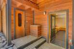 Step onto the charming wooden deck leading to a rustic sauna entrance, perfect for unwinding.