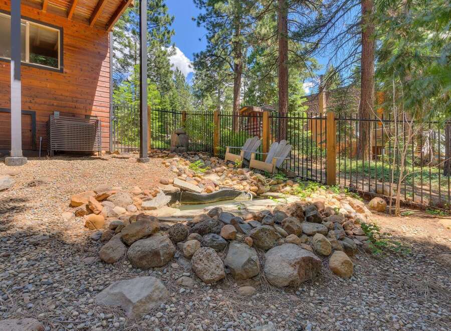 Escape to this charming mountain retreat featuring a rustic wooden exterior and a serene backyard oasis.