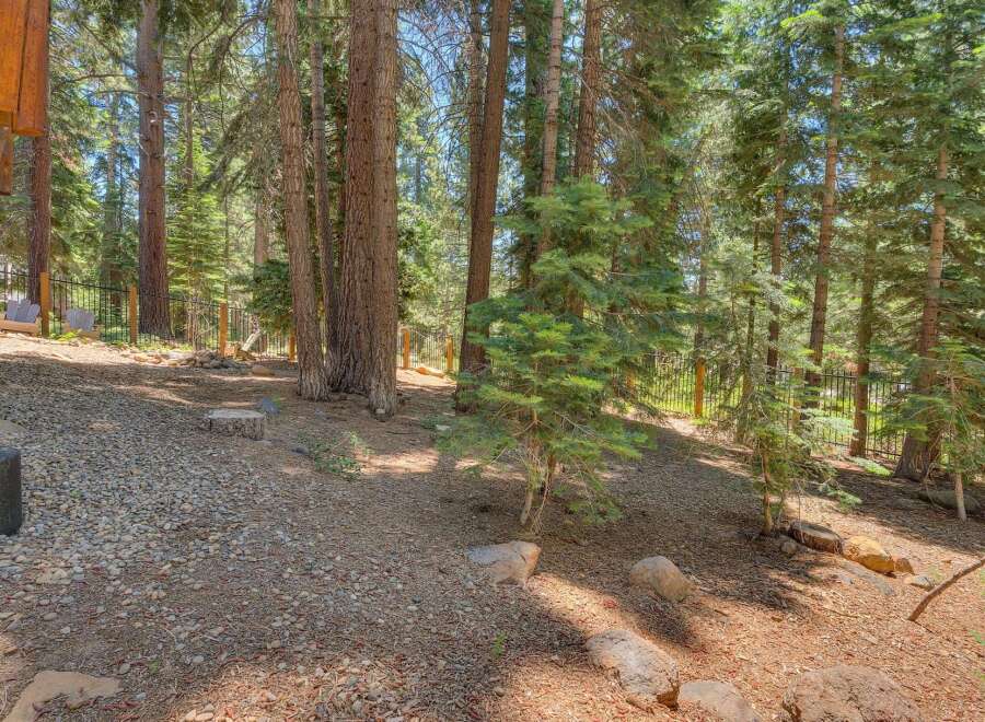 Nestled within a serene forest setting, this property offers a tranquil escape with its natural landscaping and mature trees.