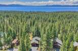 Nestled amidst a dense forest of towering pine trees, this property offers a serene retreat with breathtaking views of a vast blue lake and distant snow-capped mountains.