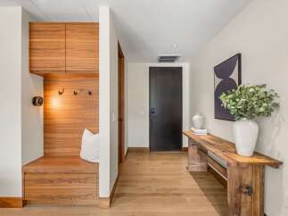 Step into this inviting entryway featuring a custom wood-paneled mudroom with ample storage and a comfortable bench.