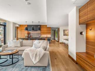 Experience modern luxury in this open-concept living space, featuring a sleek kitchen with ample wood cabinetry and a sophisticated island.